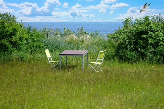 Garden furniture on green lawn with views of the Baltic Sea