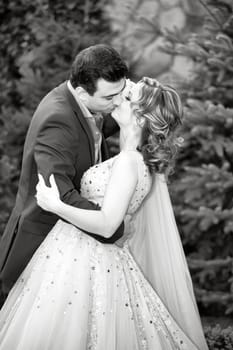 Newly wed couple kissing outdoor on a summer day.
