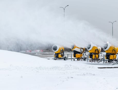 Shot of the industrial machinery so called snow gun or snow cannon that produces artificial snow in action.