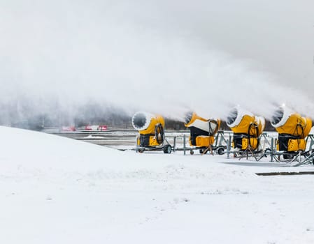 Shot of the industrial machinery so called snow gun or snow cannon that produces artificial snow in action.