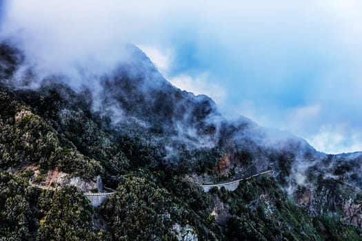 Clouds over mountain peak with winding road in Tenerife Canary island, Spain