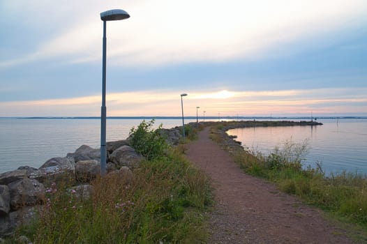 Sunset in Sweden at the harbor of lake Vaettern. Lighthouse in the background at dusk. Landscape shot in Scandinavia.