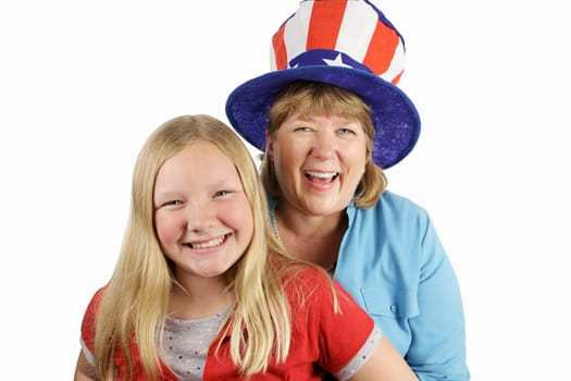 A mother and daughter dressed for fourth of july.  The focus is on the mother in the hat, laughing.  Isolated on white.