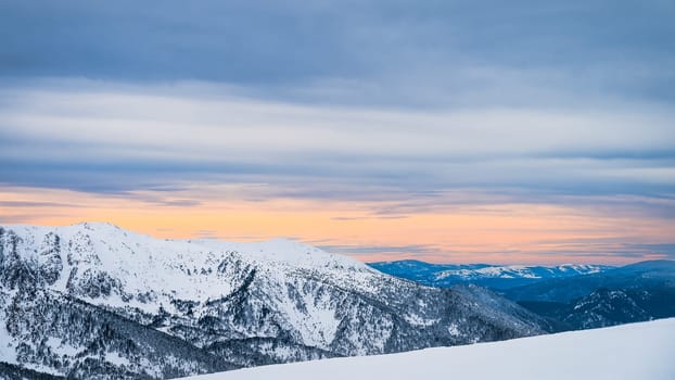 Snow capped mountain peaks of the Pyrenees Mountains. Forest on mountain heals. Sunset at El Tarter village, Grandvalira, Andorra