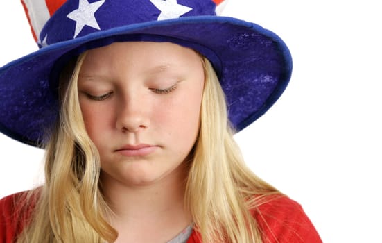 A beautiful young girl wearing a patriotic American hat and looking sad.