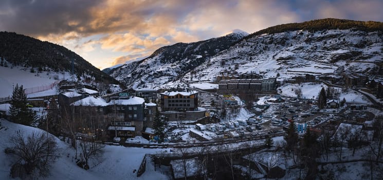 El Tarter village after dusk or at night fall with last sunlight illuminating mountain peaks in Pyrenees mountains, Grandvalira, Andorra