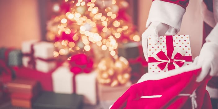 View of hands of Santa Claus with giftbox in his hans indoors. Concept of Christmas and New Year.
