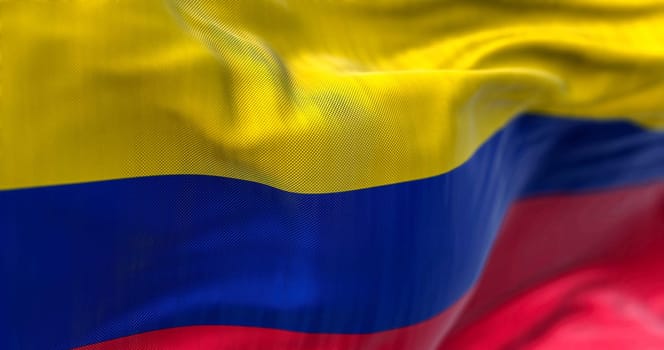Close-up view of Colombia National flag waving. The Republic of Colombia is a state in the north-western region of South America. Fabric textured background. Selective focus