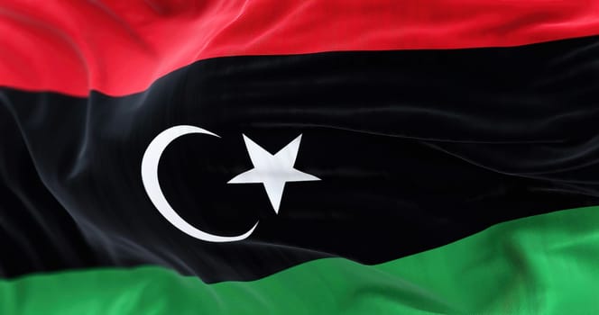 Close-up view of Libya National flag waving. The State of Libya is a State of North Africa. Fabric textured background. Selective focus