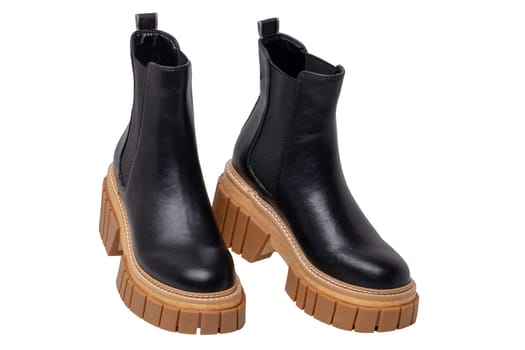Ladies Chelsea boots. Close-up of a pair womens black leather chelsea boots with high heels isolated on a white background. Clipping path. Fashion advertisment shoes.