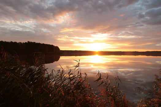 Sunrise over the lake on a cloudy autumn day