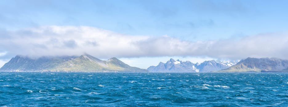 Widescreen panoramic view of South Georgia, a dreamlike island where king penguins and elephant seals say goodnight to each other