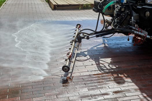 A special machine washes city paths and roads with water. High quality photo