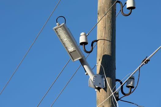 The LED street light is attached to a wooden pole. High quality photo