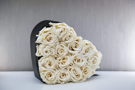A heart box filled with many white roses. Motif for Valentine's Day.