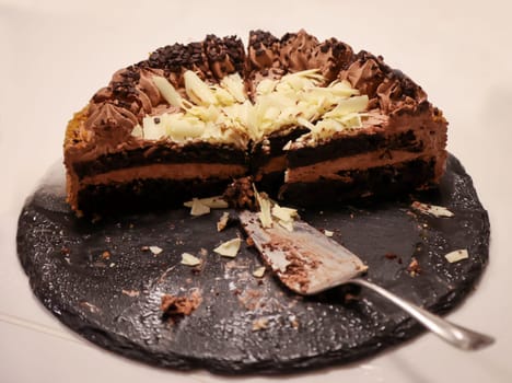 A cake, stands cut on a table.