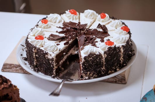 A cake, stands cut on a table.