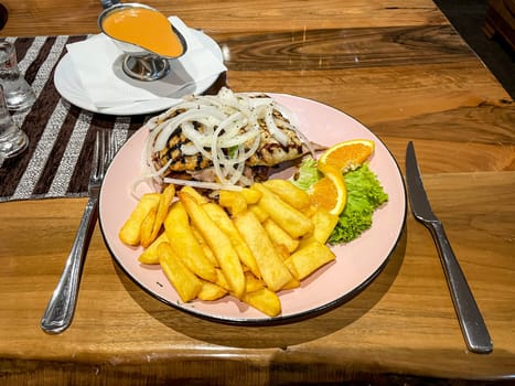 A plate of grilled meat and fries on a plate.