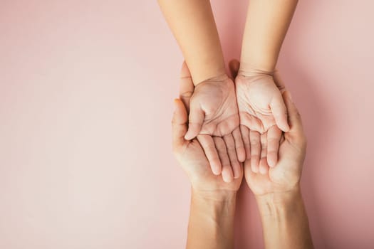 Close up hands children on adult mother hand, Top view person kid stack mom palms, Parents and little kid holding empty hands together isolated on pink background, Family day care concept