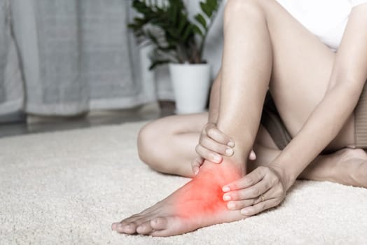 Foot pain, Woman holds her ankle injury feeling pain in her foot at home, female suffering from feet ache use hand massage relax muscle from ankle in home interior, Healthcare problems and medical