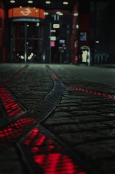 Red luminous rails on the forecourt in front of a headquarter in Bochum, Germany.