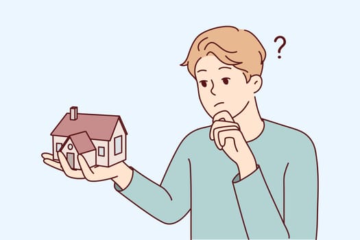 Young man holding house thinking of mortgage or loan. Confused male with home maquette frustrated with housing rent or purchase. Real estate agent. Vector illustration.