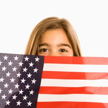 Girl peeking over American flag against white background.