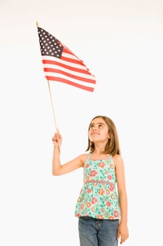 Girl holding American flag against white background.