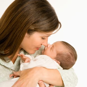 Mother nuzzling sleeping baby with nose and smiling.