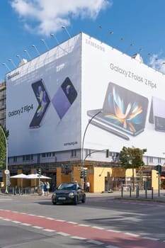 Street scene on Kantstrasse in Berlin. In the background at a construction site advertising for a smartphone.