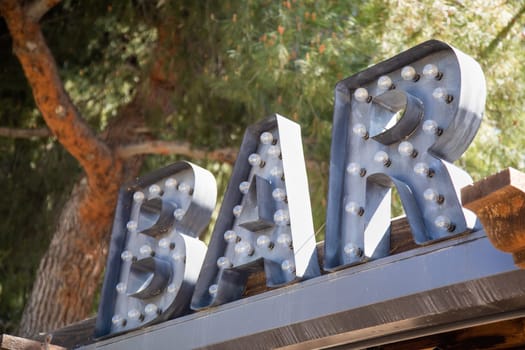 Industrial Marquee letters Bar Sign with Bulbs on Roof of Business.