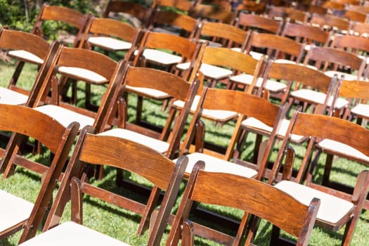 Rows of Wooden Event Chairs at Wedding Venue Abstract.