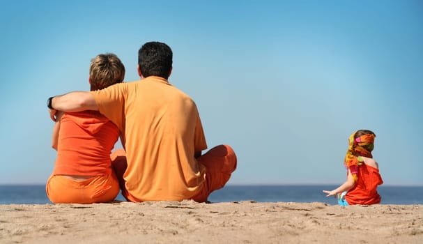 Family in orange clothes on the beach