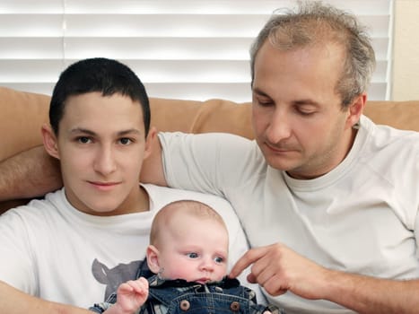 Three generations of men sitting on a couch