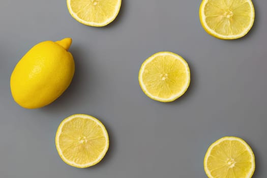 Yellow lemons on gray background. Colors of the Year 2021 Illuminating and Ultimate gray, flat lay