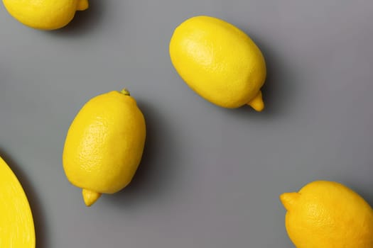 Yellow lemons on gray background. Colors of the Year 2021 Pantone Illuminating and Ultimate gray, flat lay