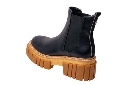 Ladies Chelsea boots. Close-up of a single womens black leather chelsea boots with high heels isolated on a white background. Macro. Fashion advertisment shoes.