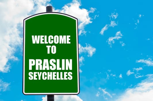 Green road sign with greeting message Welcome to PRASLIN, SEYCHELLES isolated over clear blue sky background with available copy space. Travel destination concept  image