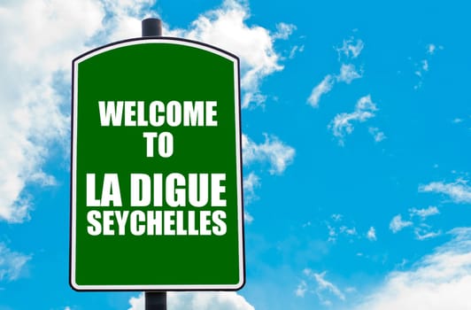 Green road sign with greeting message WELCOME TO LA DIGUE, SEYCHELLES isolated over clear blue sky background with available copy space. Travel destination concept  image