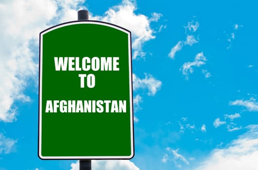 Green road sign with greeting message WELCOME TO AFGHANISTAN, isolated over clear blue sky background with available copy space. Travel destination concept  image