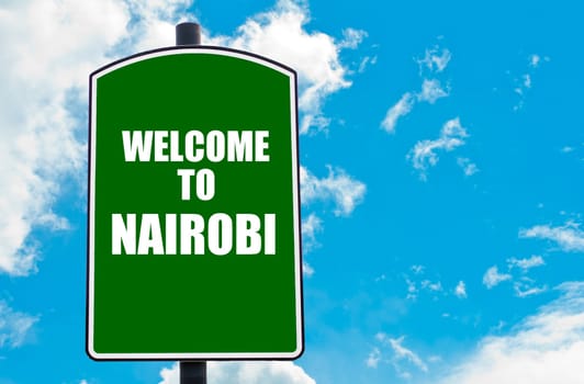 Green road sign with greeting message WELCOME TO NAIROBI  isolated over clear blue sky background with available copy space. Travel destination concept  image