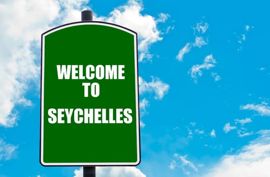 Green road sign with greeting message WELCOME TO SEYCHELLES isolated over clear blue sky background with available copy space. Travel destination concept  image