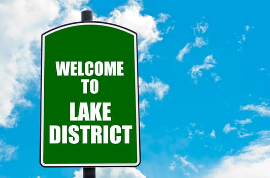 Green road sign with greeting message Welcome to LAKE DISTRICT isolated over clear blue sky background with available copy space. Travel destination concept  image