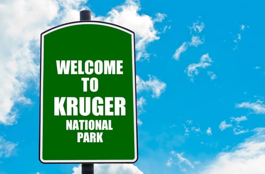 Green road sign with greeting message Welcome to KRUGER NATIONAL PARK isolated over clear blue sky background with available copy space. Travel destination concept  image