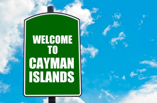 Green road sign with greeting message WELCOME TO CAYMAN ISLANDS isolated over clear blue sky background with available copy space. Travel destination concept  image