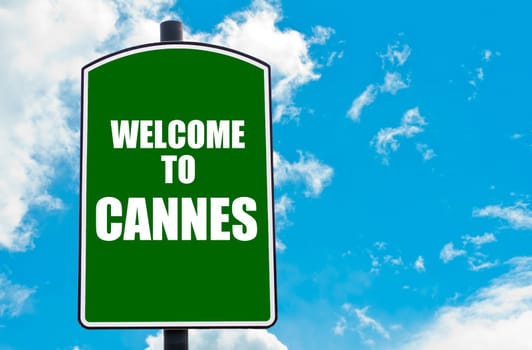 Green road sign with greeting message WELCOME TO CANNES isolated over clear blue sky background with available copy space. Travel destination concept  image