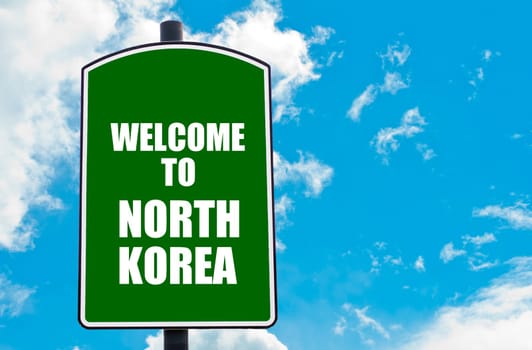 Green road sign with greeting message WELCOME TO NORTH KOREA isolated over clear blue sky background with available copy space. Travel destination concept  image