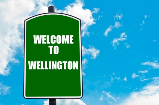 Green road sign with greeting message WELCOME TO WELLINGTON, NEW ZEALAND isolated over clear blue sky background with available copy space. Travel destination concept  image