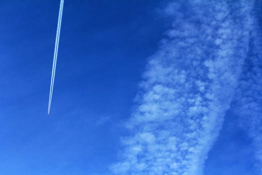 A plane with condensate stripes in the blue sky