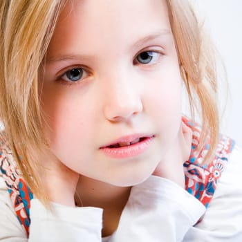 Close-up studio portrait of a blond young girl